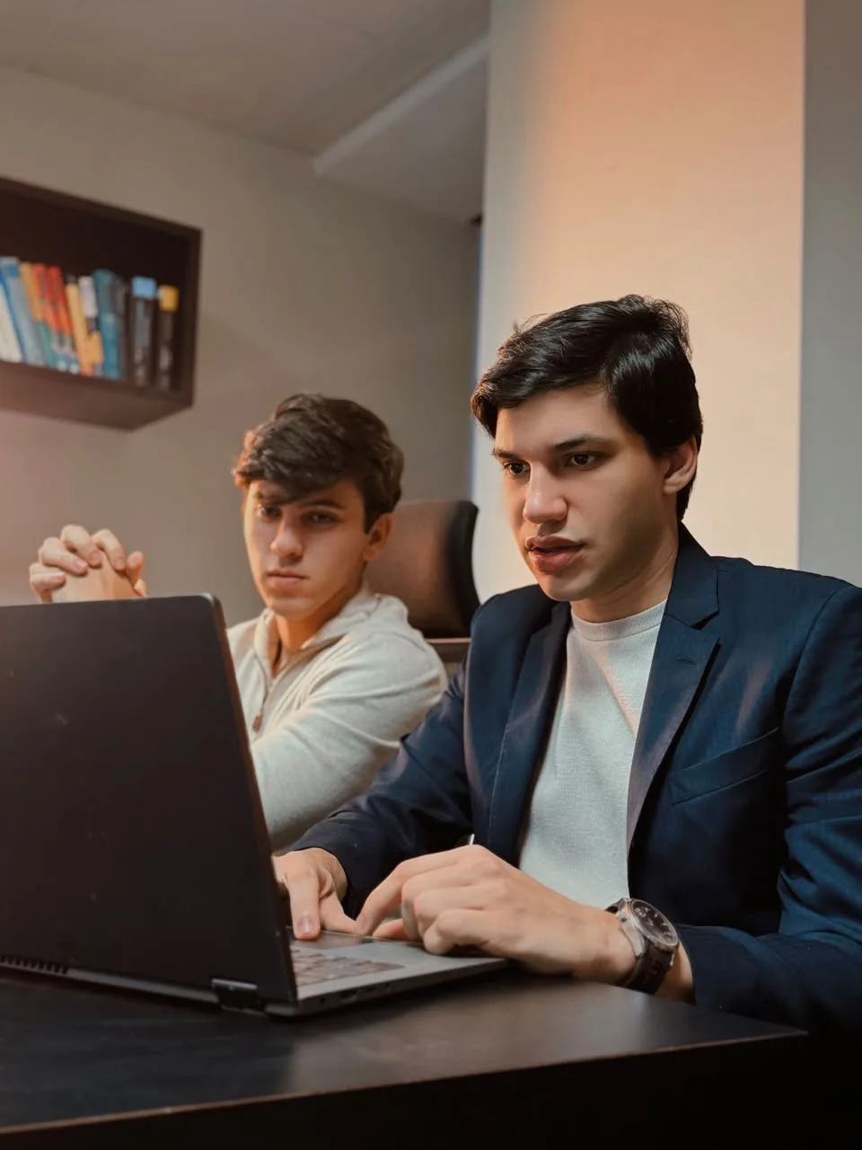 Os sócios da Axial trabalhando juntos em um notebook no escritório